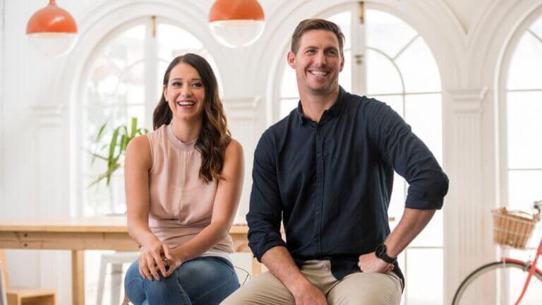 Two MyBudget clients, Jaz and Reed, smiling and sitting on bar stools
