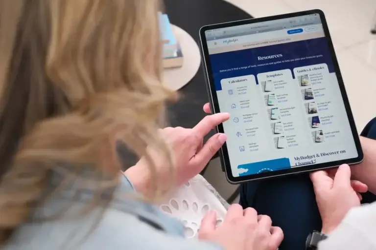 A couple are looking at an iPad featuring the MyBudget website's resources page.