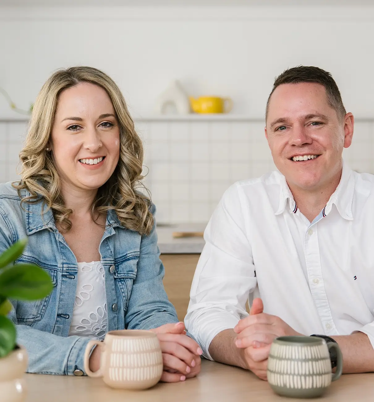 MyBudget clients Adam and Erin celebrate success at the dining table after achieving financial goals and debt solutions in New Zealand.