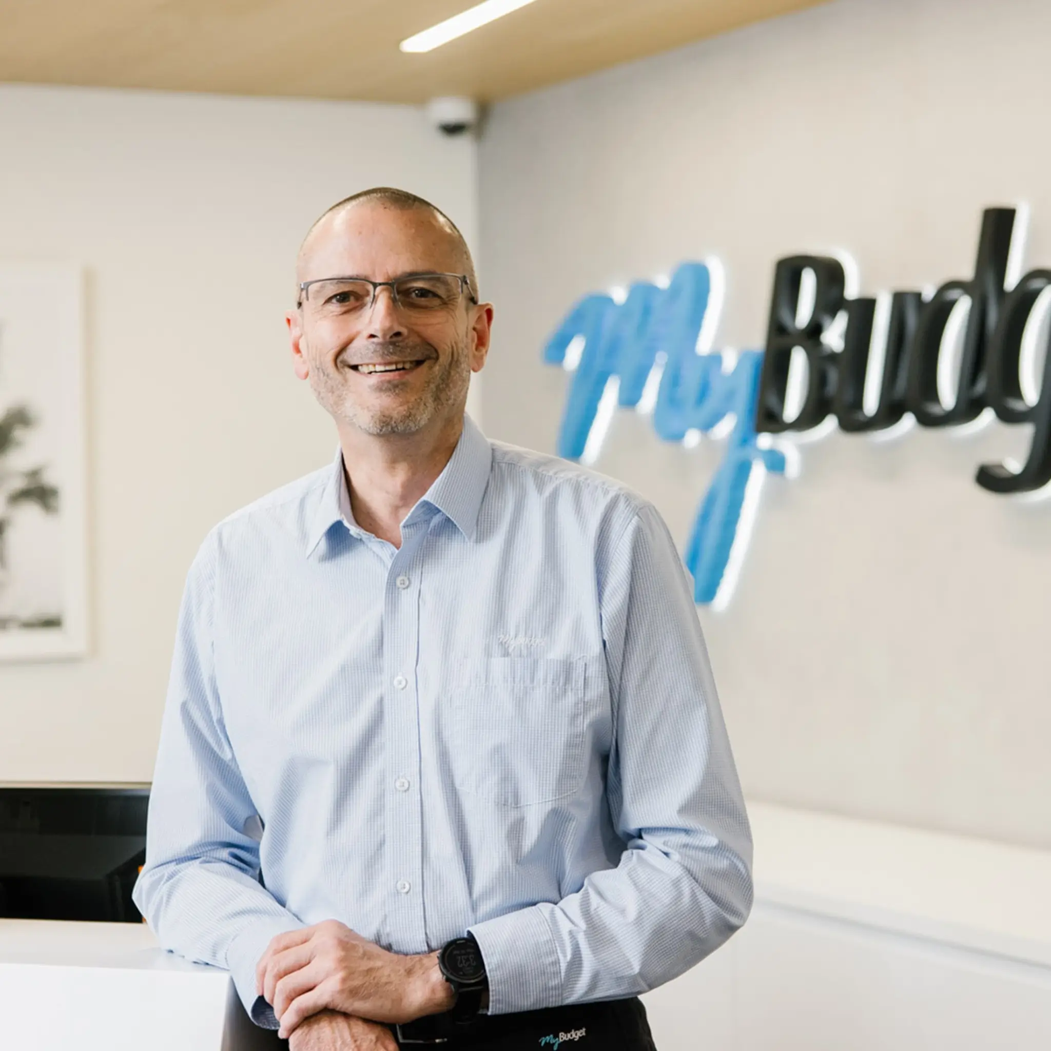 A smiling MyBudget team member at reception of the MyBudget offices.